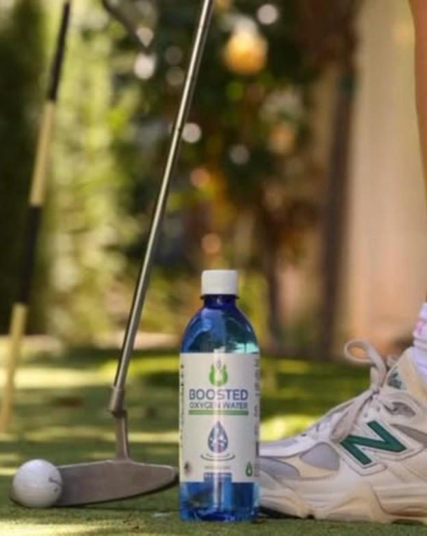 Boosted bottle on a putting green next to a golf ball